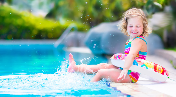 Cute Little Girl splashing in swimming pool